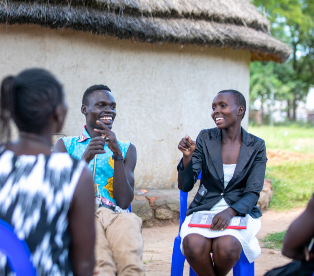 A group of individuals speak in a circle in Uganda