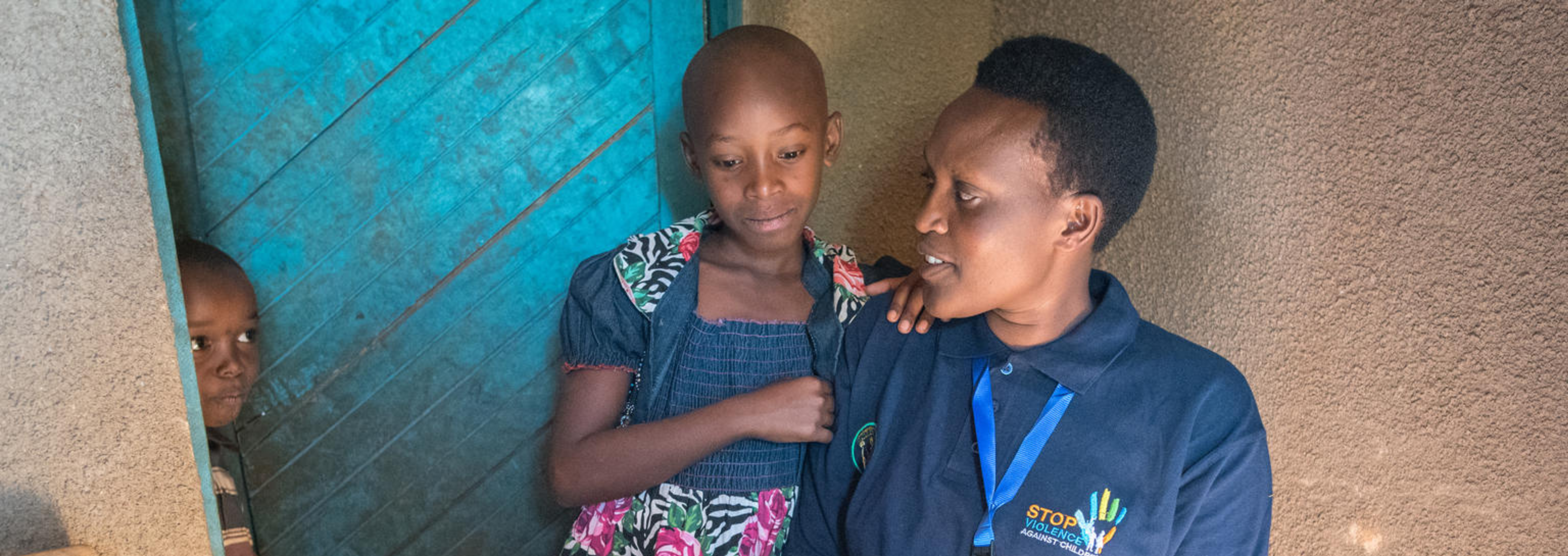 One of Rwanda’s Inshuti z’Umuryango, “Friends of the Family” assists two children.